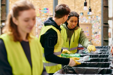 Photo for Young volunteers in gloves and safety vests sorting trash together in a community effort. - Royalty Free Image