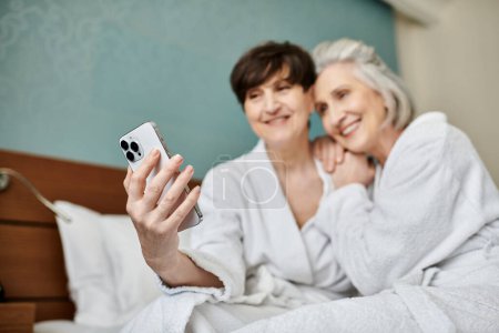Ältere Frauen halten einen Moment mit ihrem Handy fest.