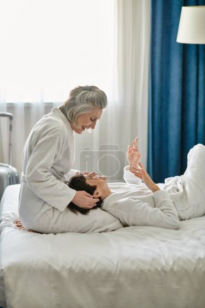 Women in a white robes lay on bed