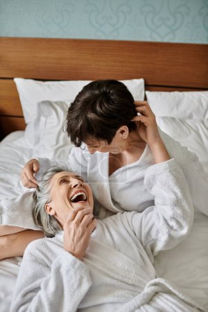 tierna amor entre senior lesbiana pareja en cama.