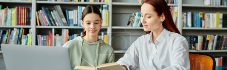 Téléchargez les photos : Tuteur rousse enseigne adolescente dans une bibliothèque, à la fois absorbé dans l'ordinateur portable - en image libre de droit