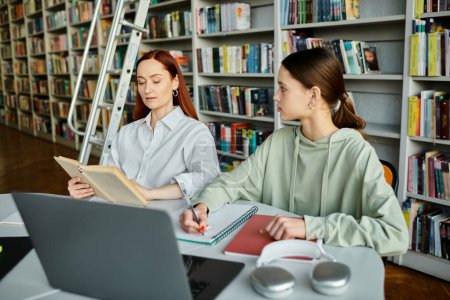 Un tutor pelirrojo educa a una adolescente en una biblioteca, usando una computadora portátil para lecciones extraescolares.