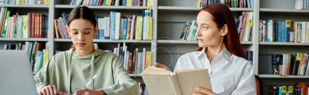 Foto de Un tutor de cabello rojo enseña a una adolescente en una biblioteca entre estanterías altas, con un portátil abierto para la educación moderna. - Imagen libre de derechos