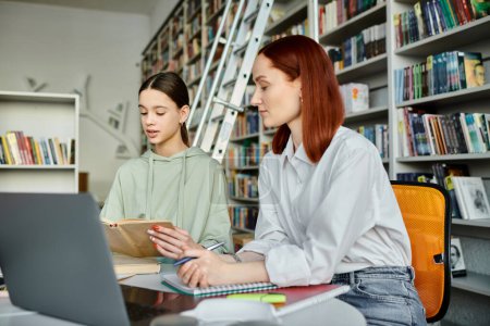 Eine rothaarige Tutorin und ein Mädchen im Teenageralter bei lebhaftem Nachmittagsunterricht an einem Büchertisch, konzentriert auf einen Laptop-Bildschirm.