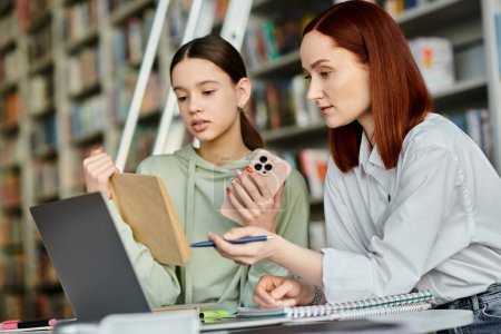Un tutor con el pelo rojo enseña a una adolescente en una biblioteca, utilizando un ordenador portátil para los recursos educativos modernos.