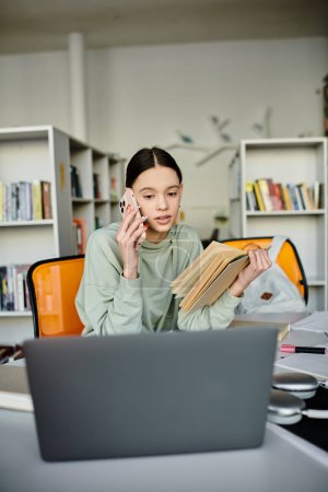 Eine junge Frau, vertieft in ihr Studium, sitzt an einem Schreibtisch mit Laptop und Buch und konzentriert sich auf moderne Bildung.