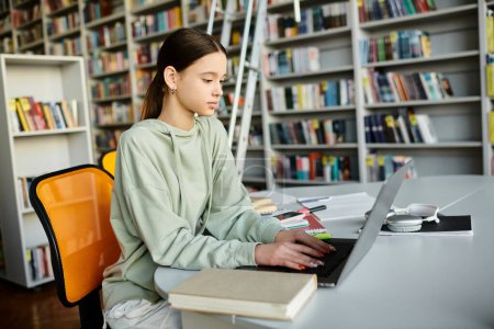 A teenage girl diligently studying at her desk with a laptop, surrounded by shelves bursting with books.