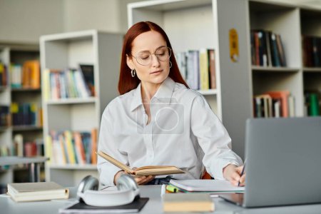 Eine rothaarige Frau, eine Tutorin, nimmt an einer Online-Unterrichtsstunde mit einem Laptop in einem ruhigen Bibliotheksambiente teil.
