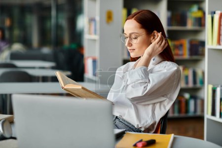 Une femme rousse engloutie dans un livre dans un cadre de bibliothèque serein, absorbée par la lecture et l'apprentissage.