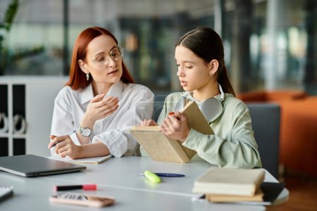 Eine rothaarige Frau unterrichtet ein Teenager-Mädchen an einem Tisch, das nach der Schule im Unterricht beschäftigt ist.