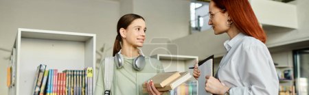 Une rousse donne des cours particuliers à une adolescente dans une bibliothèque, bannière