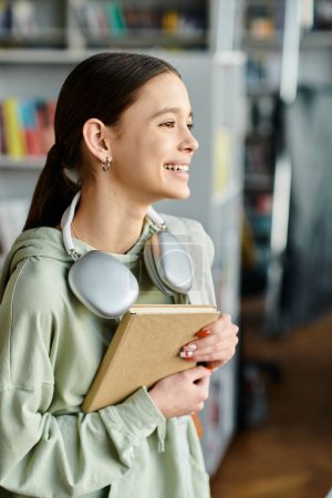 niña con auriculares sostiene un libro mientras se dedica a una lección después de la escuela