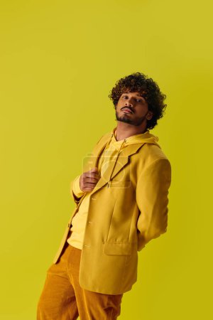 Foto de Hombre indio guapo se levanta en traje amarillo contra fondo amarillo. - Imagen libre de derechos
