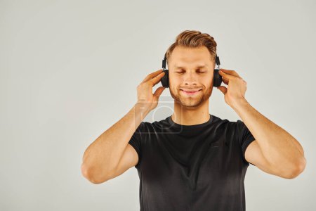 Téléchargez les photos : A man immersed in his own world, listening to music through headphones. - en image libre de droit