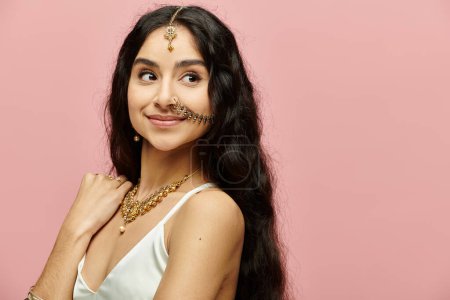 Téléchargez les photos : Jeune femme indienne aux cheveux longs et bijoux frappant une pose gracieuse. - en image libre de droit