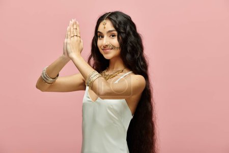 Téléchargez les photos : Une jeune femme indienne aux cheveux longs frappant une pose gracieuse. - en image libre de droit