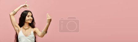 Foto de Mujer india con estilo con gracia posa delante de vibrante telón de fondo rosa. - Imagen libre de derechos
