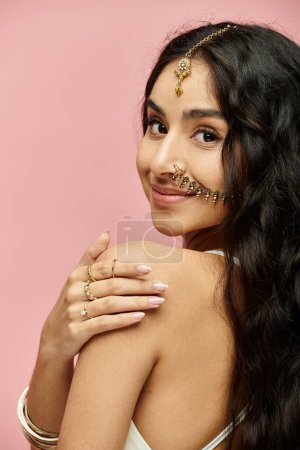 Téléchargez les photos : Jeune femme indienne arborant les cheveux longs et élégants bijoux en or dans une pose captivante. - en image libre de droit