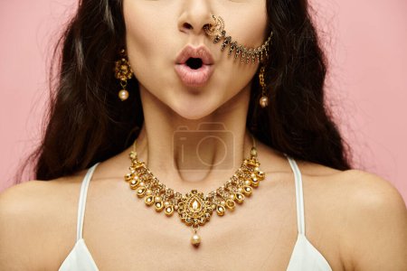 An alluring indian woman adorned in gold jewelry flaunts a nose piercing.