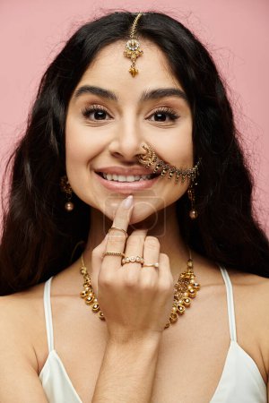Téléchargez les photos : Belle femme indienne aux cheveux longs et bijoux en or frappant une pose - en image libre de droit