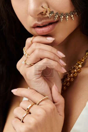 A stylish young indian woman proudly wears a shimmering gold nose ring.