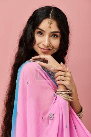 mujer india en un sari rosa golpeando una pose.