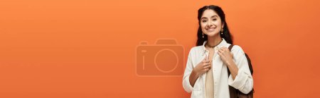 Photo for A indian woman beams with joy on a vibrant orange backdrop. - Royalty Free Image
