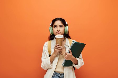 Young indian woman in headphones enjoying coffee.