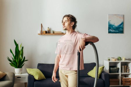 A man in cozy homewear vacuums his living room.