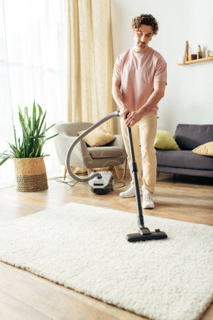 A handsome man in cozy homewear diligently vacuums his living room.