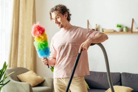 A handsome man in cozy homewear happily holds a bright, colorful duster.