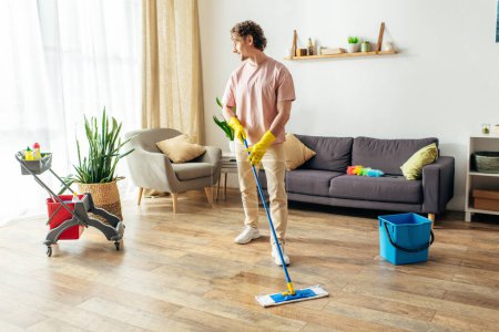 A man in cozy homewear energetically mopping the living room floor.