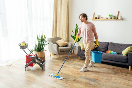 Un hombre en ropa de casa acogedora limpiando su sala de estar con una fregona.