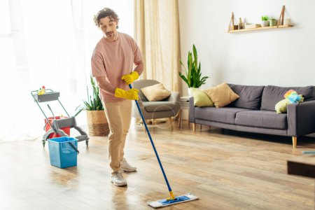 Photo for A man in home attire gracefully mops the floor. - Royalty Free Image