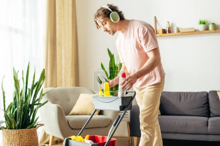 Un hombre en ropa de casa acogedora está limpiando energéticamente su sala de estar.