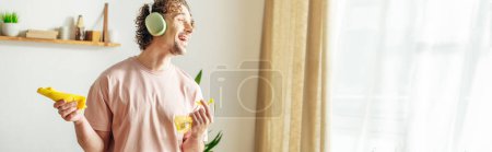 Photo for A handsome man in cozy homewear holds spray for cleaning. - Royalty Free Image