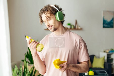 Foto de Hombre guapo en ropa de casa acogedora mientras escucha música a través de auriculares. - Imagen libre de derechos