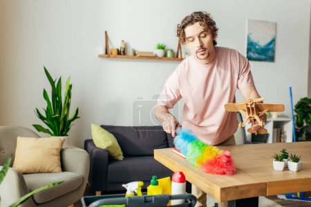 A man joyfully cleaning at home in a cozy living room.