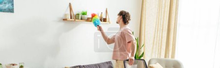 Foto de Hombre en la sala de estar, sosteniendo un plumero. - Imagen libre de derechos