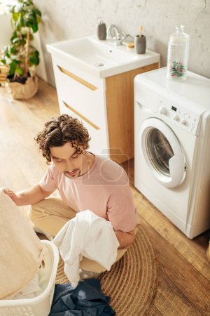 Photo for Young man busy in laundry room. - Royalty Free Image