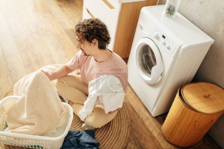 Téléchargez les photos : Homme assis près de la machine à laver. - en image libre de droit