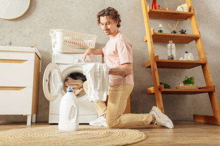 Foto de Un hombre en ropa de casa acogedora se sienta delante de una lavadora. - Imagen libre de derechos