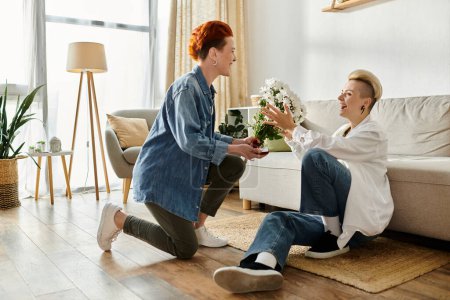 A man tenderly hands flowers to a woman in a cozy living room setting, showcasing a simple act of affection.