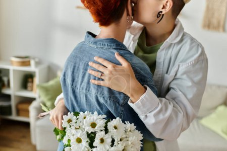 Two women with short hair, a lesbian couple, hugging each other affectionately in the warm and inviting living room.