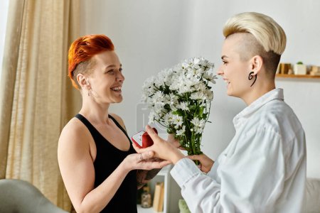 Two women with short hair exchange gifts and smiles in a cozy living room, expressing joy and affection.