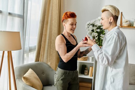 Two women with short hair happily exchanging gifts in a cozy living room setting.