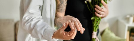 Frauen halten liebevoll einen lebendigen Blumenstrauß in einem gemütlichen Rahmen zu Hause und zeigen Verlobungsring