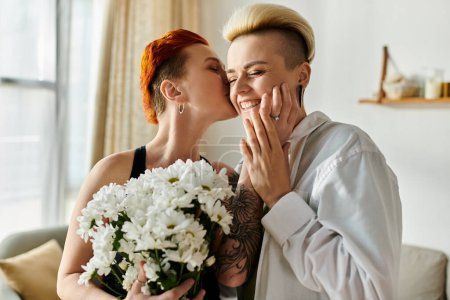 Two women with short hair embrace, hug, and kiss in a cozy living room, showing affection and love for each other.