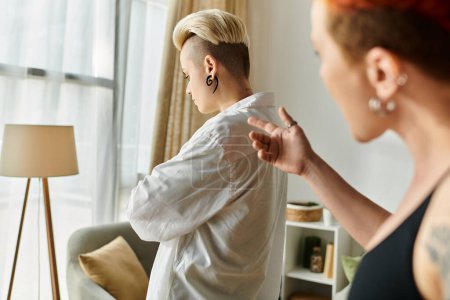 Téléchargez les photos : Deux femmes aux cheveux courts debout dans un salon, montrant malentendu et conflit - en image libre de droit