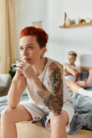 Photo for A woman with fiery red hair sits on a bed. - Royalty Free Image